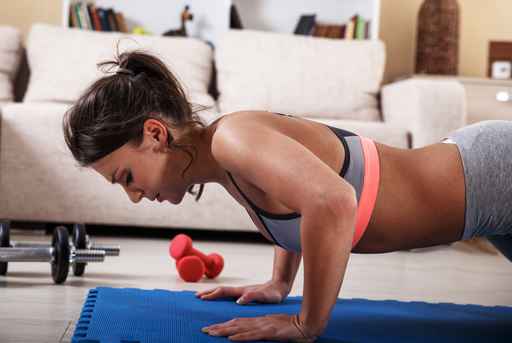 Attractive female exercise at home.Fitness.Doing push ups.