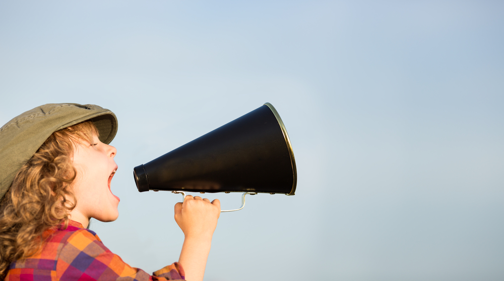 Kid shouting through vintage megaphone. 