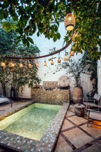 a beautiful spa outdoors with a pool and lanterns