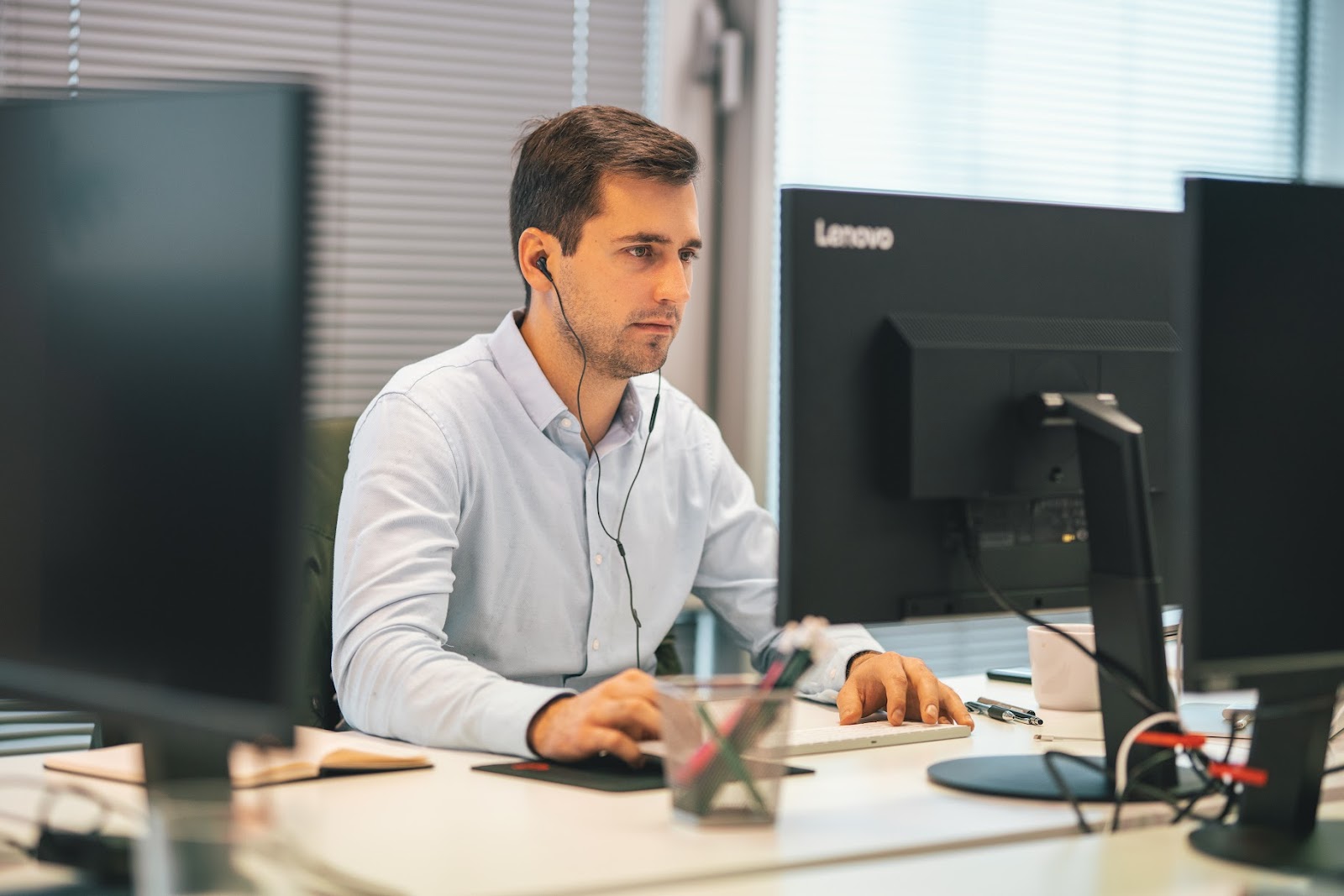 A man working at a computer using several monitors
