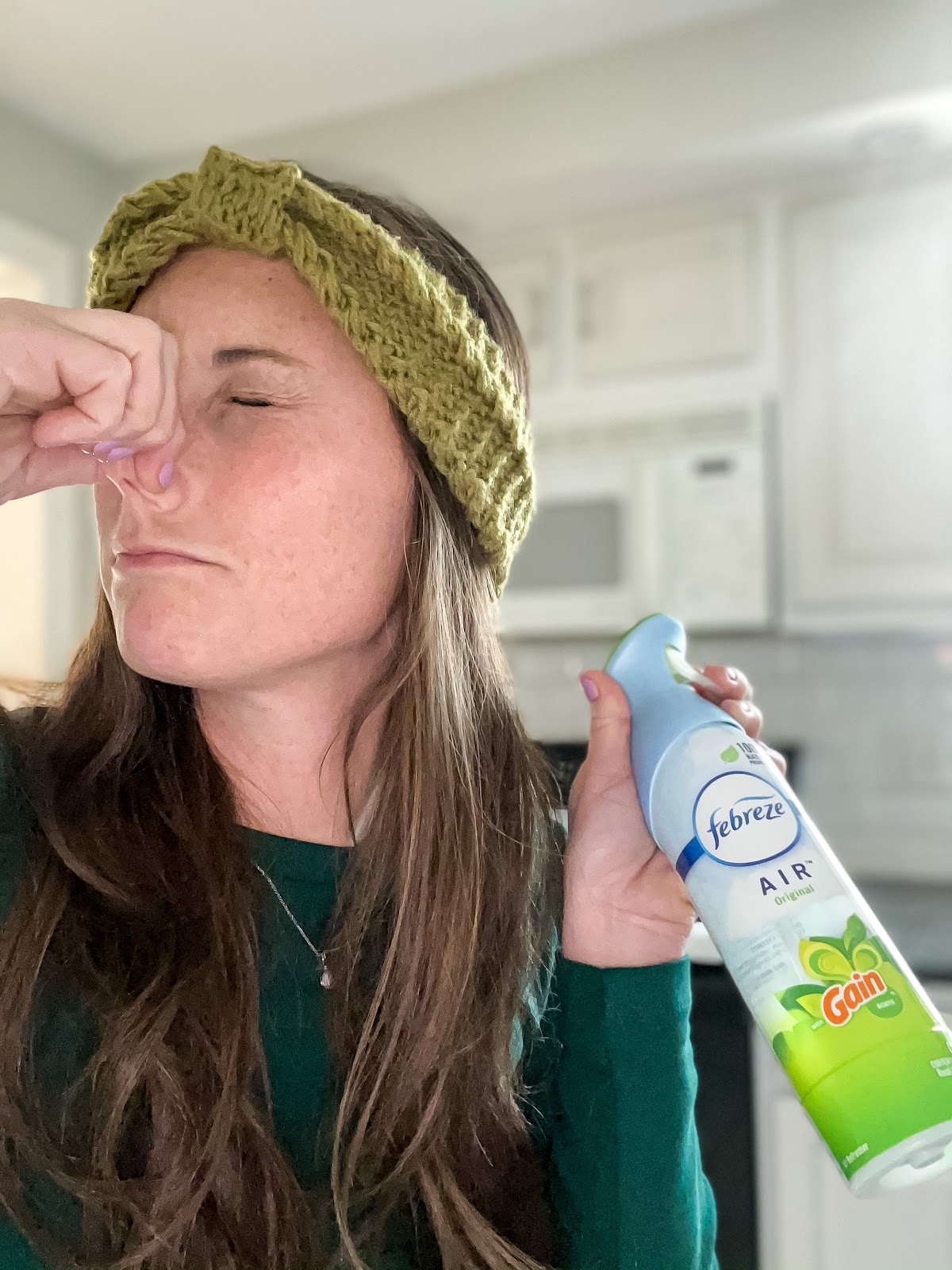 Woman holding nose with Febreeze for Homegate Clean Up