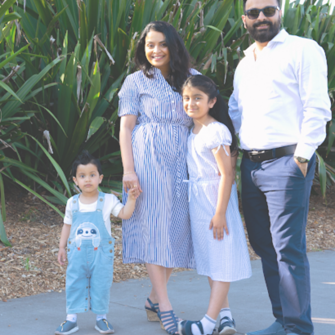  A family of four in blue and white outfits ready to pose for a photoshoot