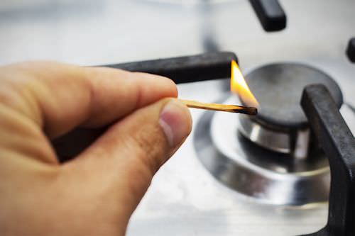 lighting a gas stove with a matchstick
