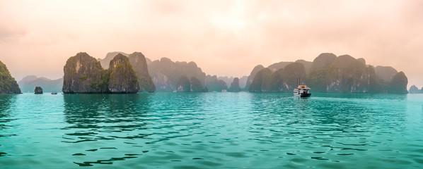 Con tàu du lịch xinh đẹp nổi giữa những tảng đá vôi ở Vịnh Hạ Long.  Đây là Di sản Thế giới được UNESCO công nhận, là một kỳ quan thiên nhiên tuyệt đẹp ở miền Bắc Việt Nam
