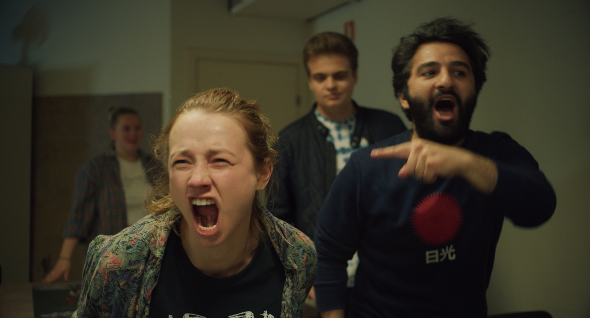 A screen still from Ninjababy, featuring Rakel, played by Kristine Kujath, yelling in the hallway of a hospital as her friends follow behind.