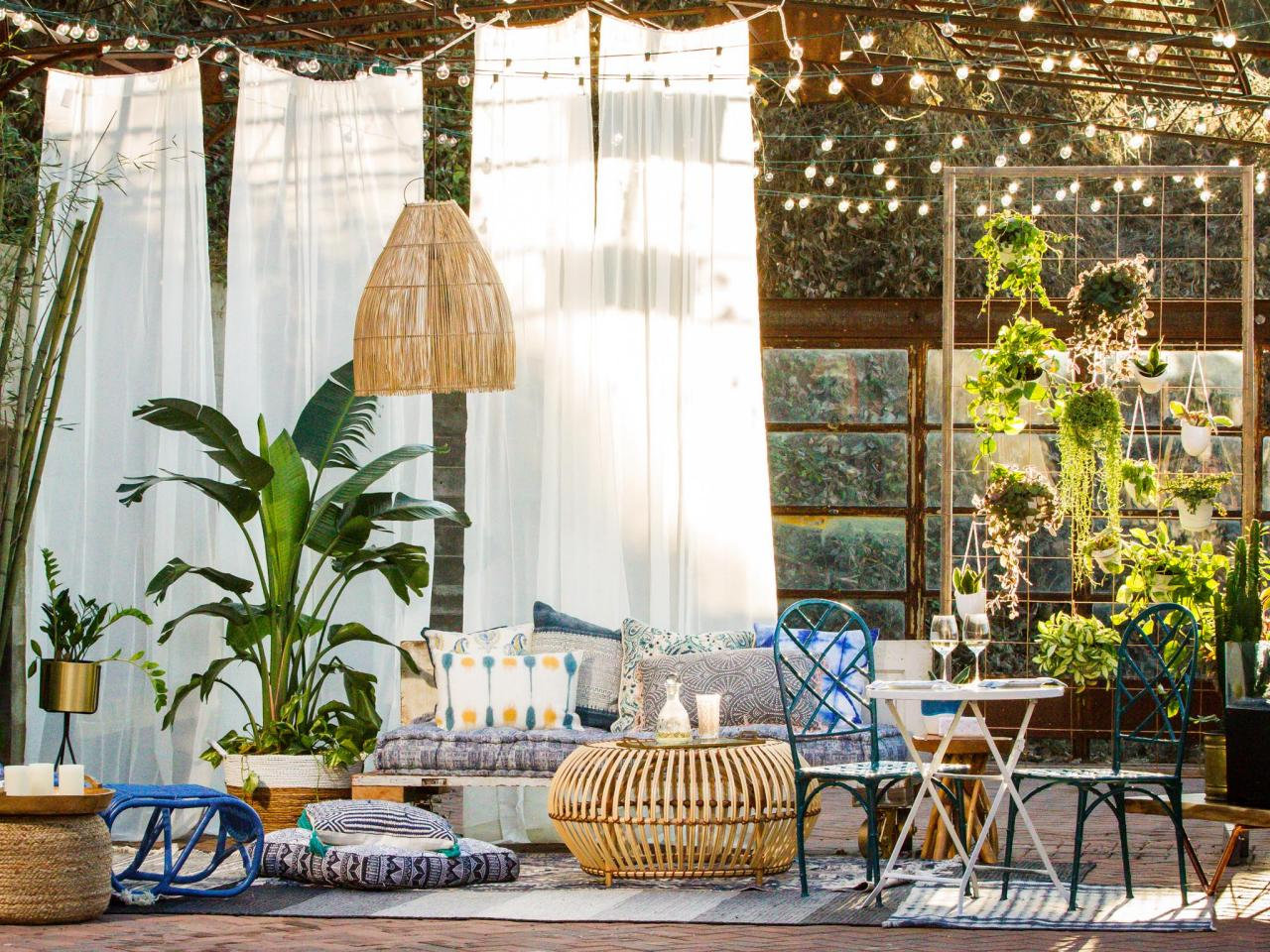Bohemian themed outdoor space with floor cushions and hanging lights to make it cozy
