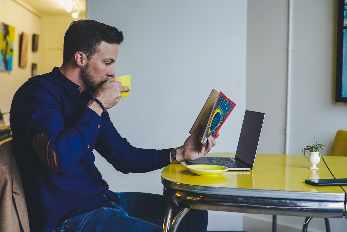 Homem lendo e tomando café