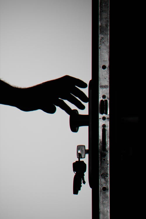 Silhouette Photo of Person Holding Door Knob