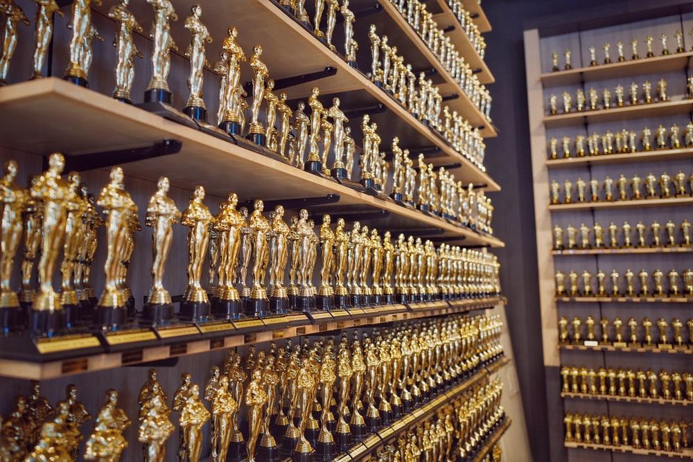Two shelves full of properly-aligned gold trophies