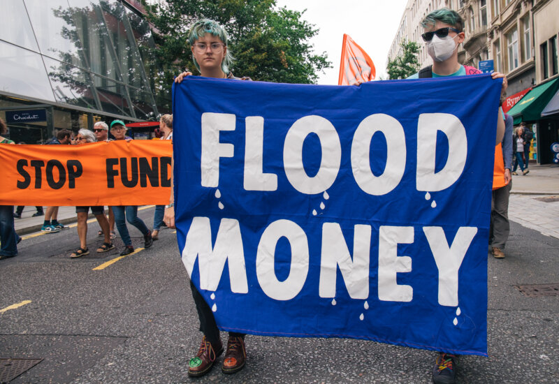 Two rebels holding a sign 'flood money'
