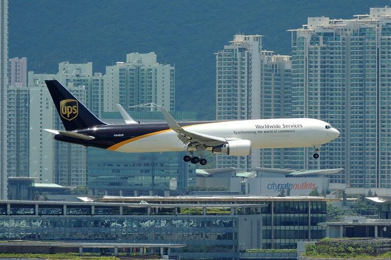 A airplane with the UPS logo on its take, flying into an international airport.