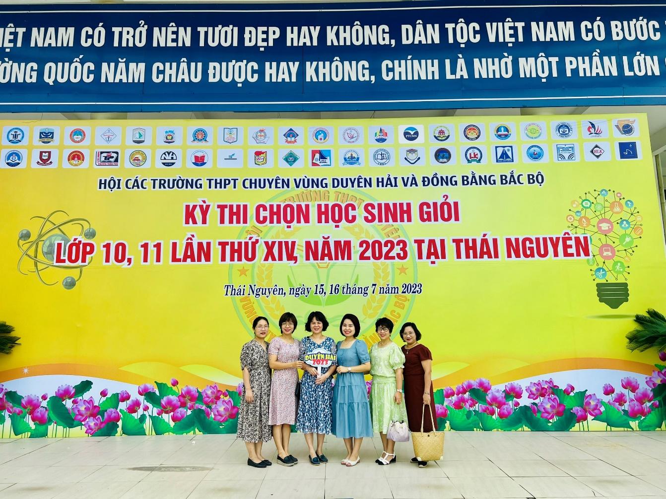 A group of women standing in front of a banner</p>
<p>Description automatically generated