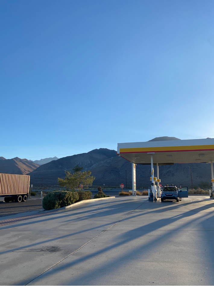 A photograph of a gas station frame against a brilliant blue sky.
