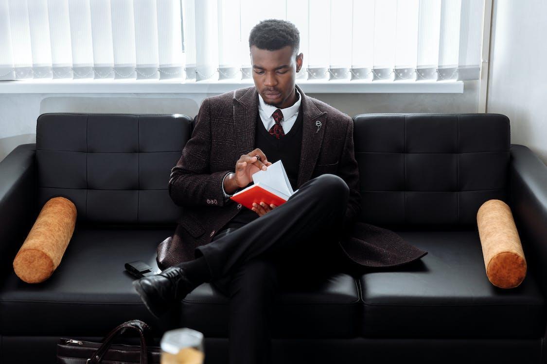 Free Man in Black Suit Sitting on Black Couch Stock Photo