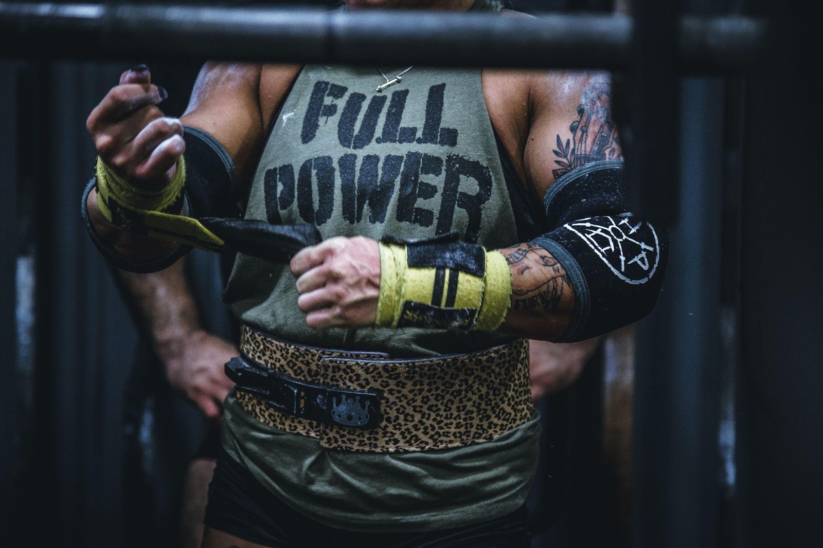 Lifter about to deadlift with a leather lifting belt on.