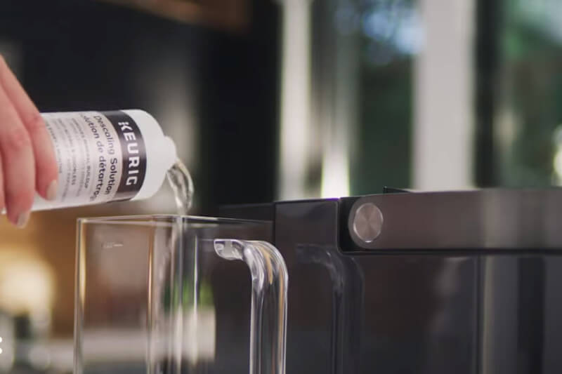                                         Pouring Descaling solution to the Keurig reservoir
