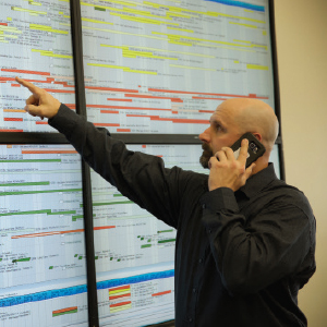 Project Manager Pointing to schedule board