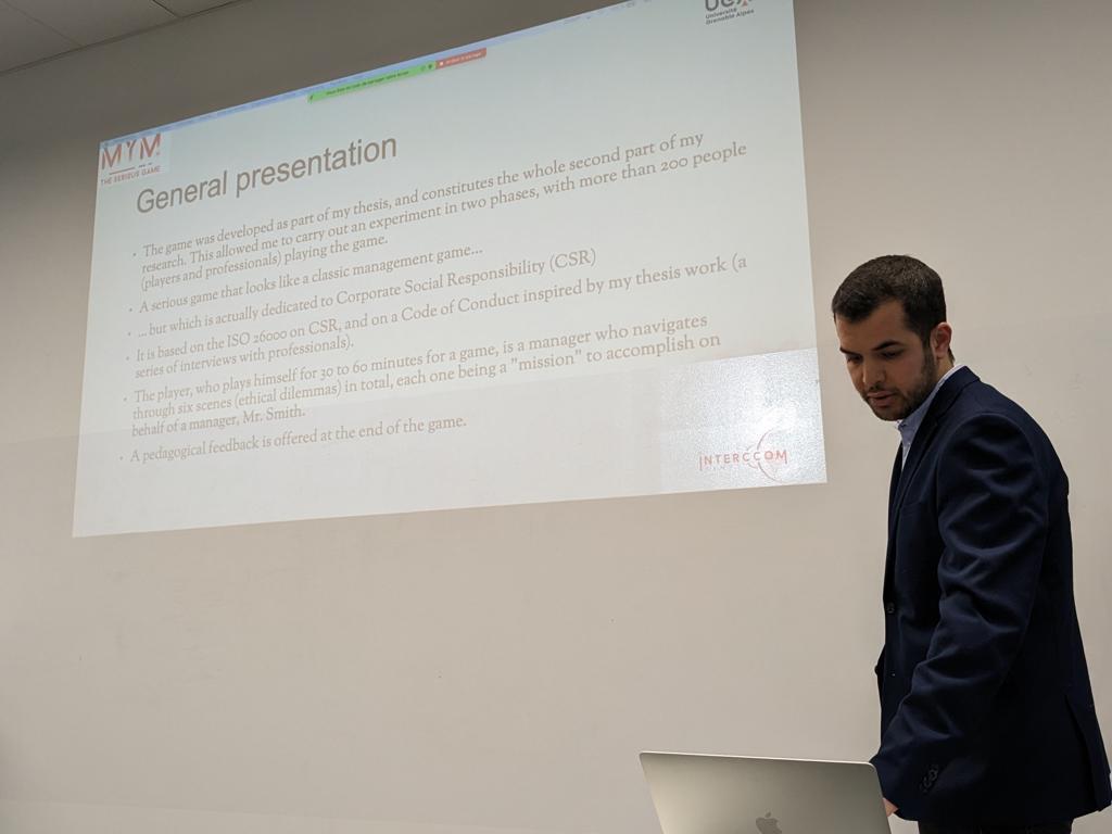 A person in a suit standing in front of a projector screen

Description automatically generated with medium confidence
