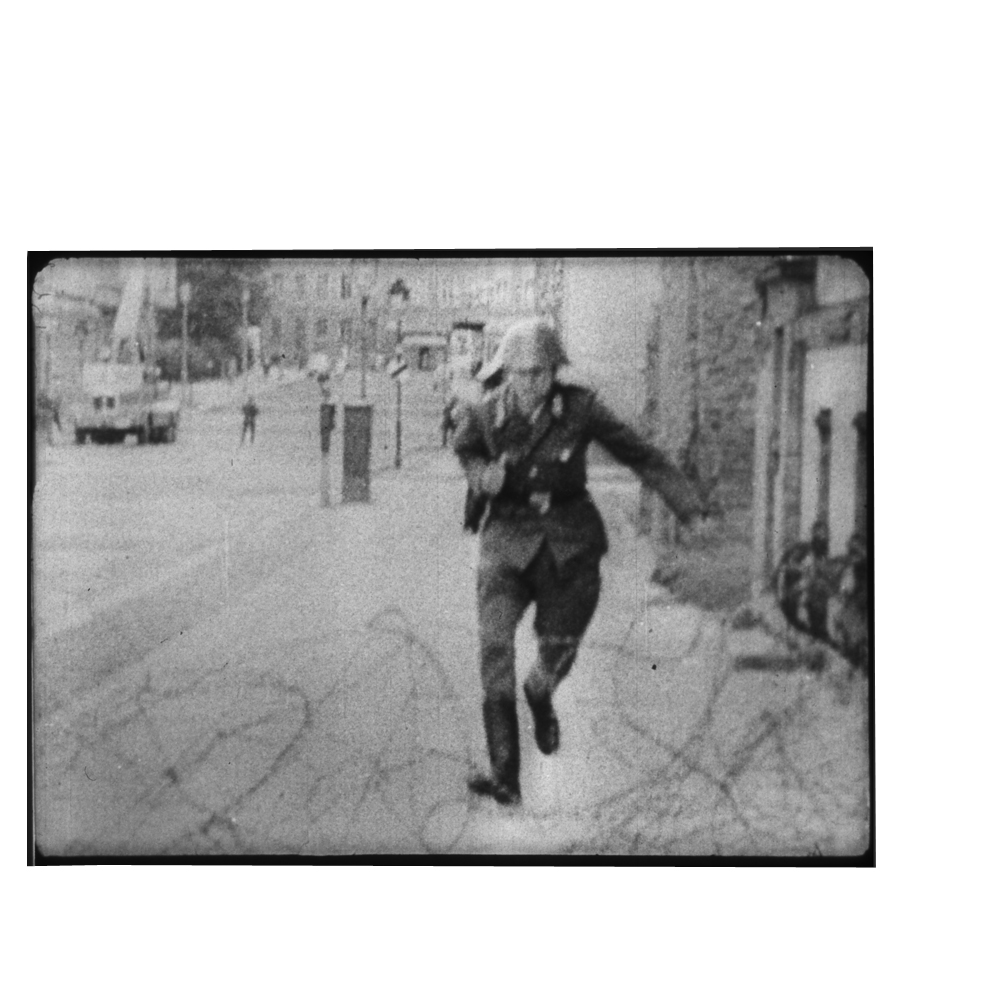 19-летний пограничник Конрад Шуманн перепрыгивает в Западный Берлин через колючую проволоку, 15 августа 1961 года