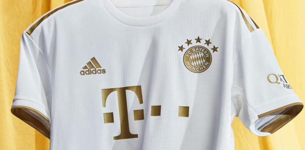 FC Bayern's away shirt returns to white with golden accents. Bayern Munich will wear their away shirt that Adidas is releasing this season in white with golden accents. 
