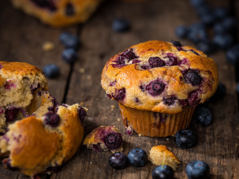 Banjo's Blueberry Muffin full of fruit on a wooden underground