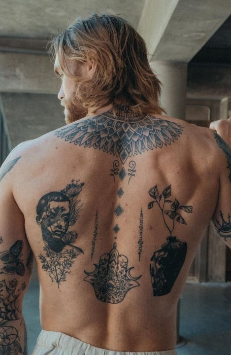 Full picture of a guy showing off his back patchwork tattoo