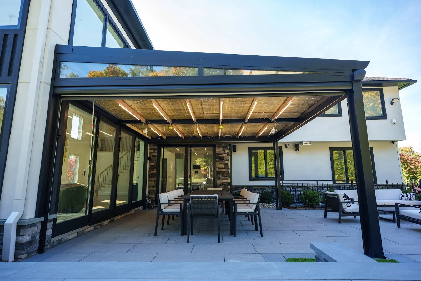 A covered pergola with a table and chairs on a patio, adorned with Sukkah decorations