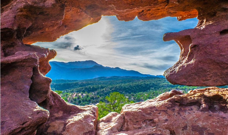 A view of the mountains through a rock formation at Garden of the Gods