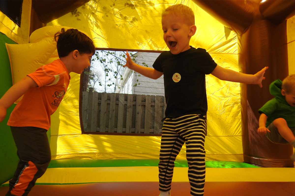 children playing in a bouncy castle for Día del Niño