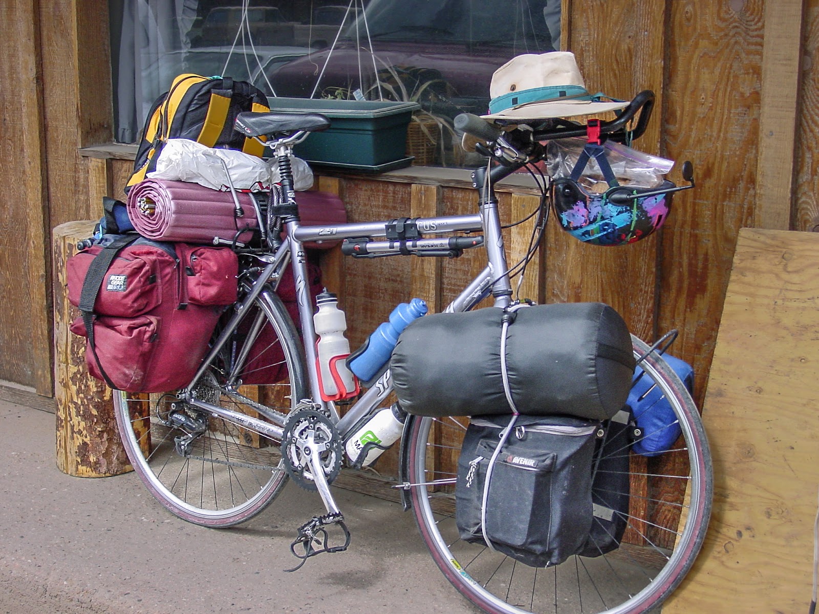 A bike loaded with gear over the front and back wheels. 