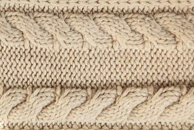 Photo close up of beige knitted winter sweater as textured material concept.