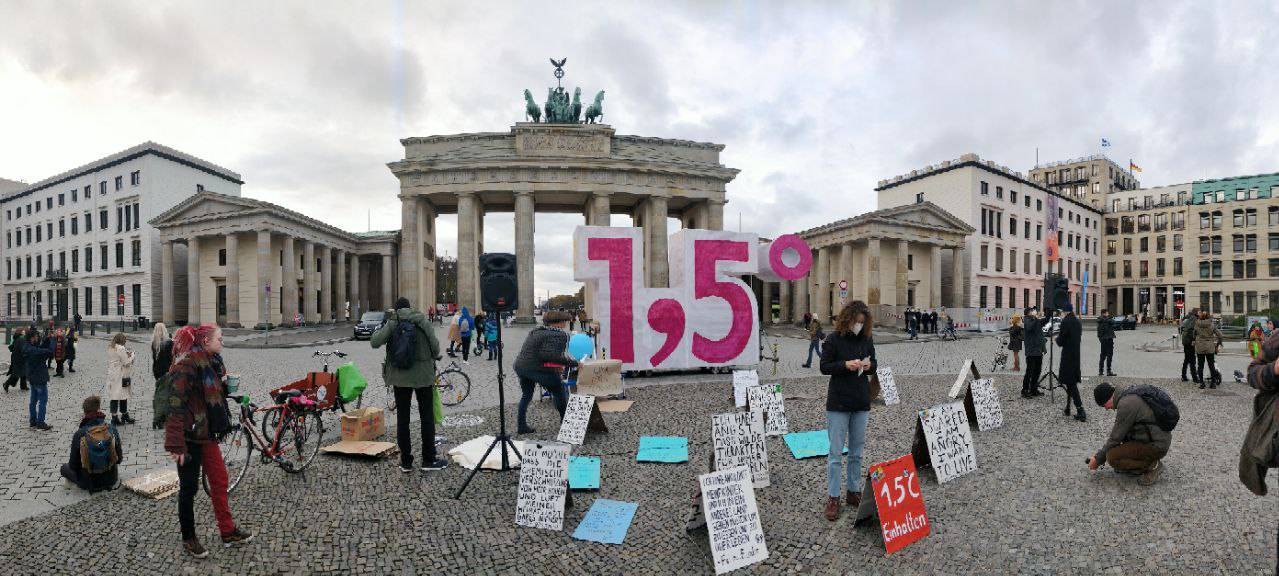 A panorama of Brandenburg gate - rebels have placed signs with quotes on the paving stones and a giant 1.5 sign.