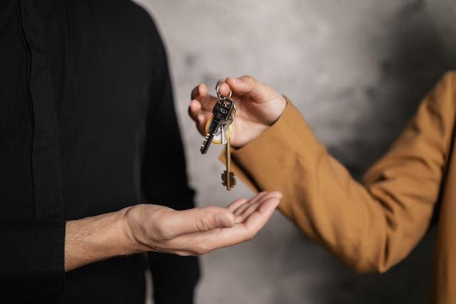 A person giving a key to another person after choosing between two great properties