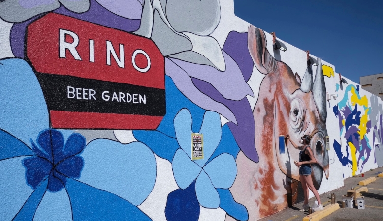 woman painting a mural in the River North Art District, a Denver neighborhood