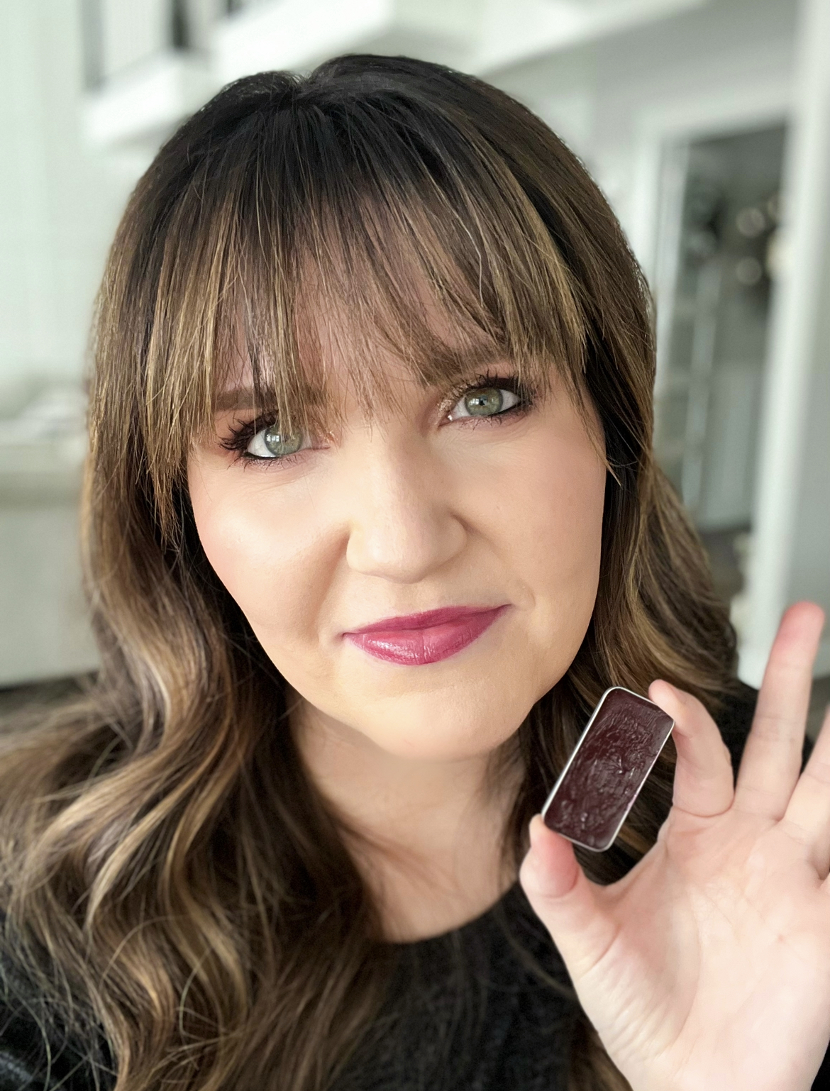 Picture of Kelly Snider holding a Seint Lip+Cheek deep berry color that's perfect for a bold lip. kellysnider.com 