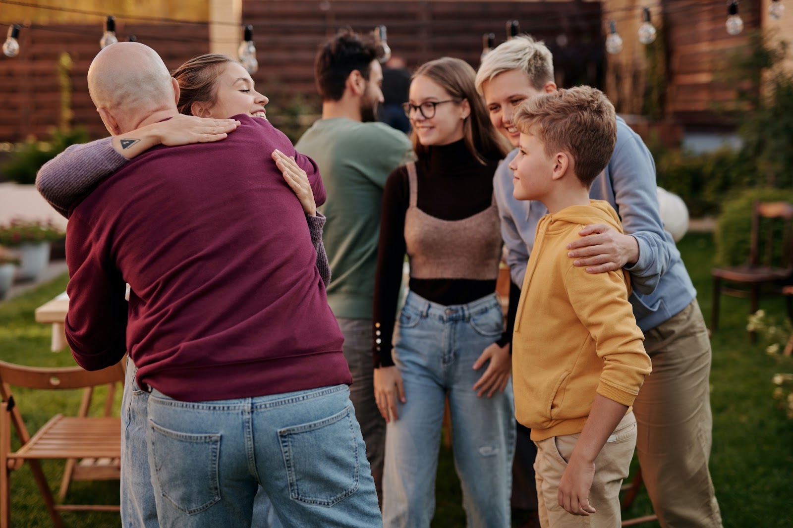 Via Pexels https://www.pexels.com/photo/happy-friends-embracing-in-summer-yard-5638577/