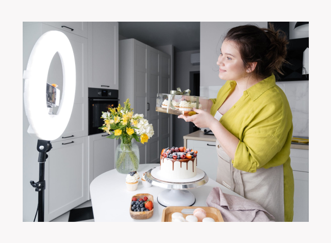 An influencer recording herself in her kitchen, showing cakes and sweets.