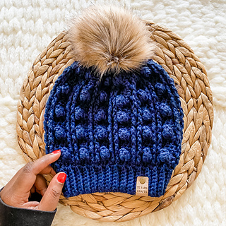 blue crocheted hat with faux fur hat lying flat