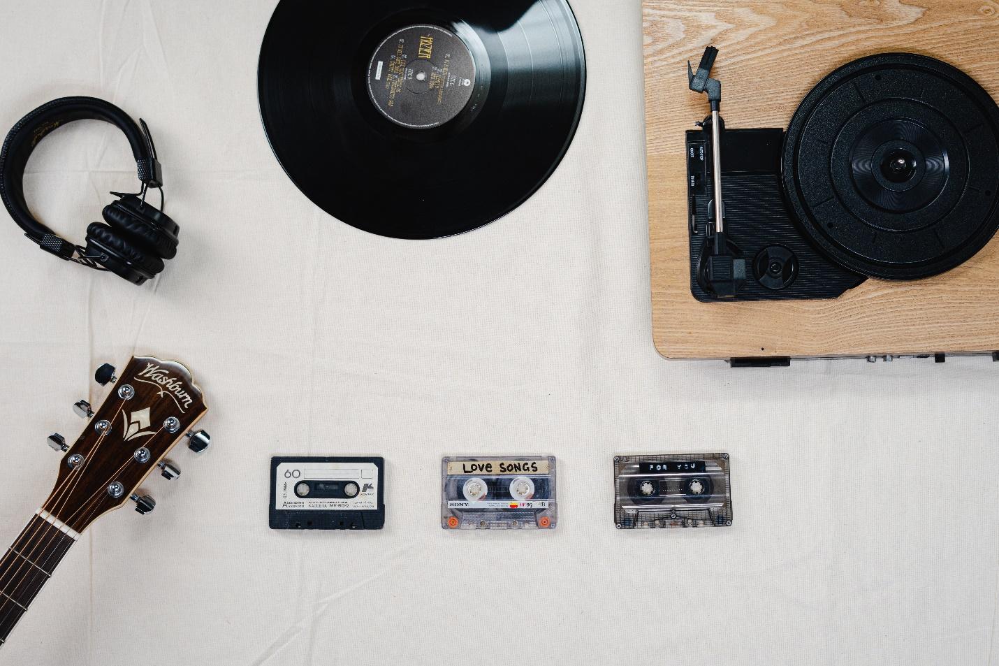 A picture of a record player, a record, headphones, a guitar and cassette tapes: How Royalties Work In Music 