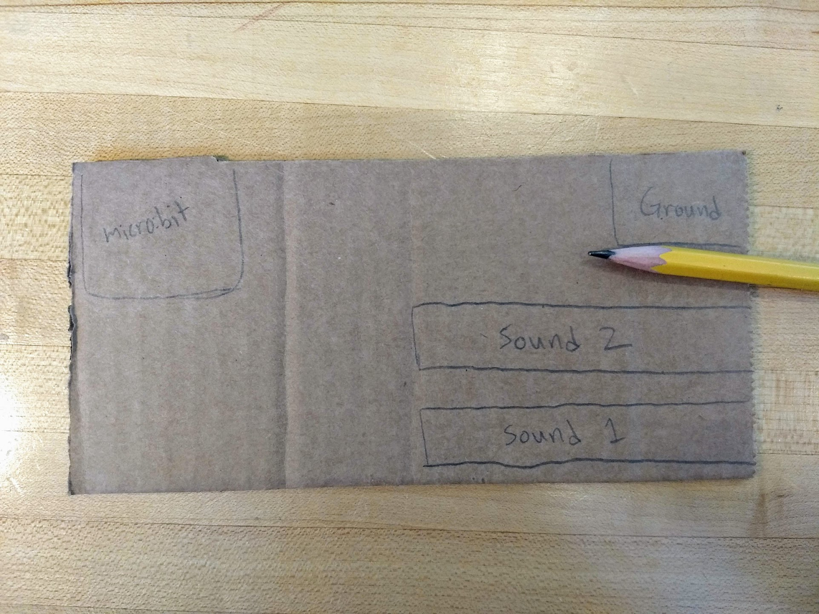 1. Draw out what you want your simple instrument to look like. You’ll need space for the micro:bit, ground, and however many sounds you want your instrument to make. Here we show two different sounds.