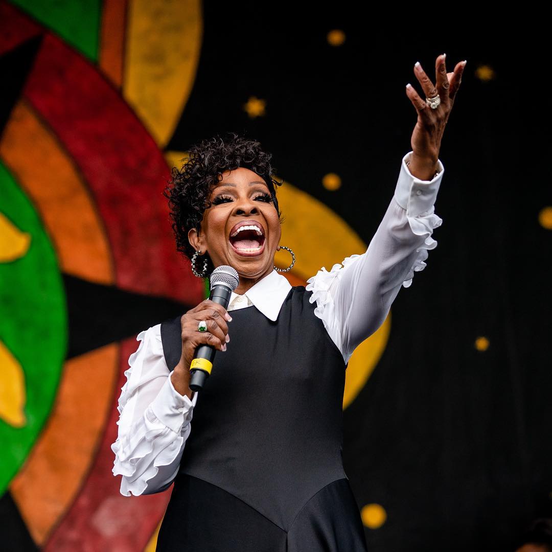 Woman singing while wearing a white shirt and black dress
