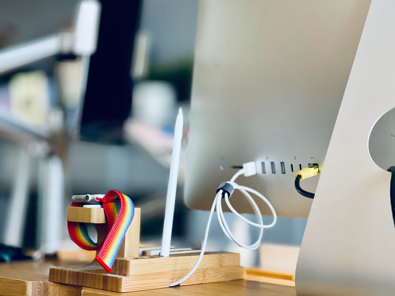 Neatly rolled cable and Apple iWatch behind a computer monitor