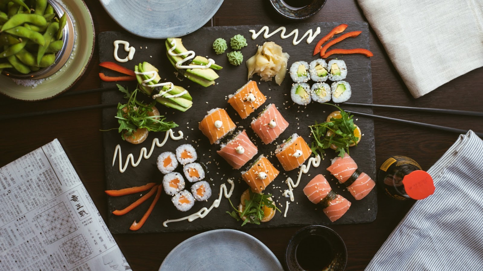 A variety of sushi and edamame beans displayed on a table