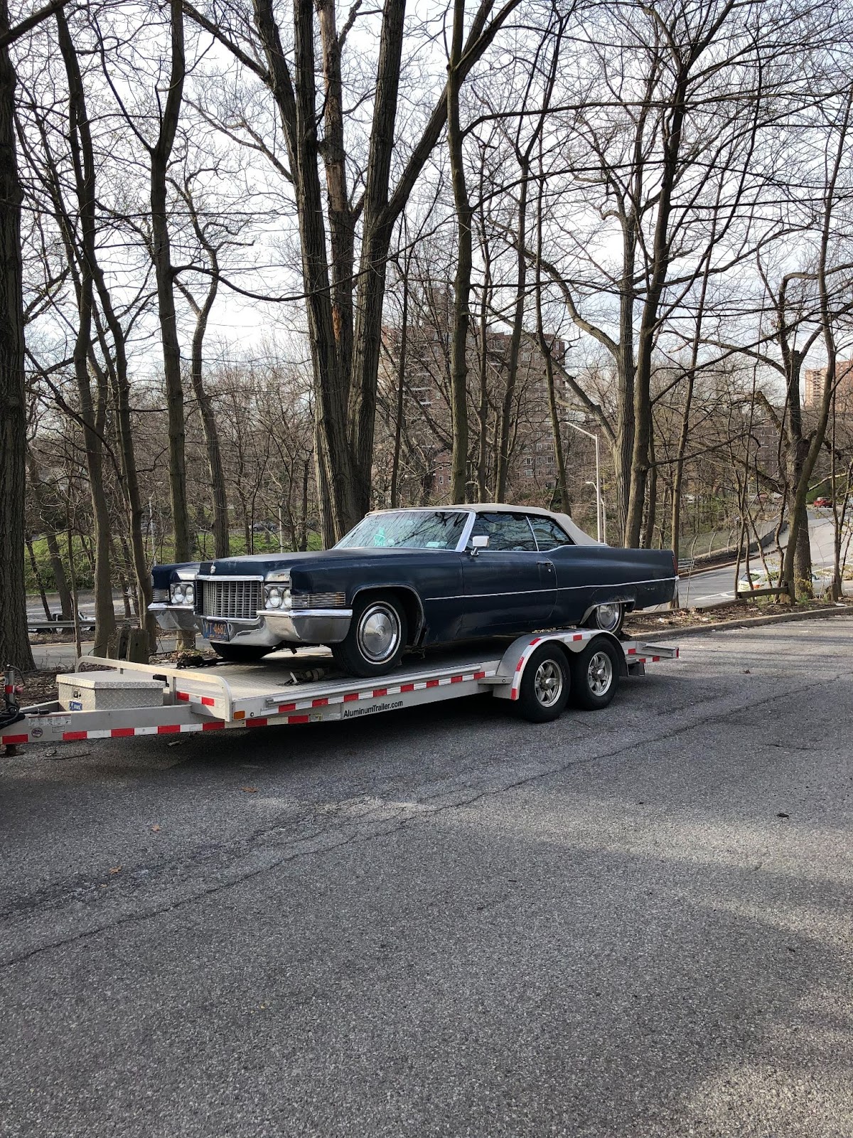 A car being pulled on a trailer bed.