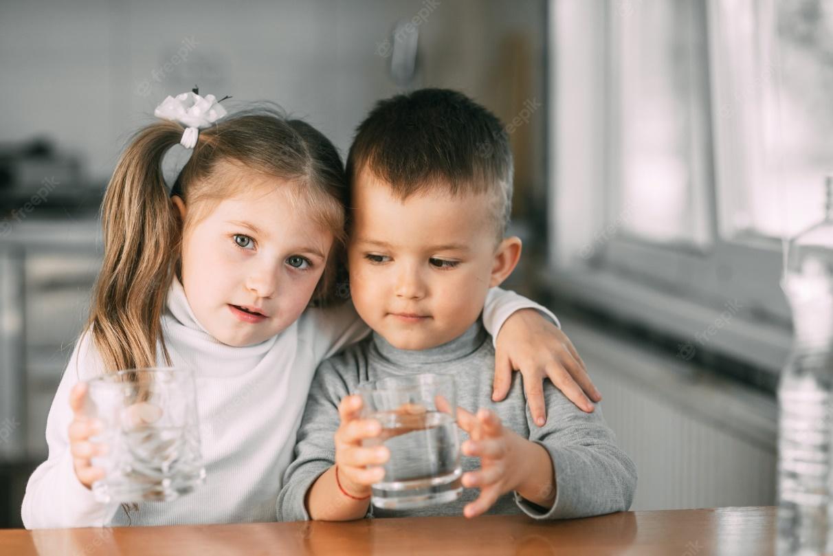 Premium Photo | Children boy and girl in the kitchen drinking water from  glasses, hugging and smiling very sweet