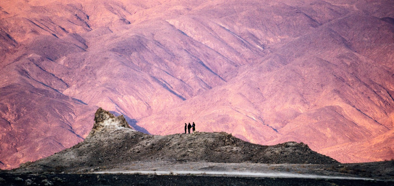 A couple of people standing on a mountain</p>
<p>Description automatically generated with low confidence