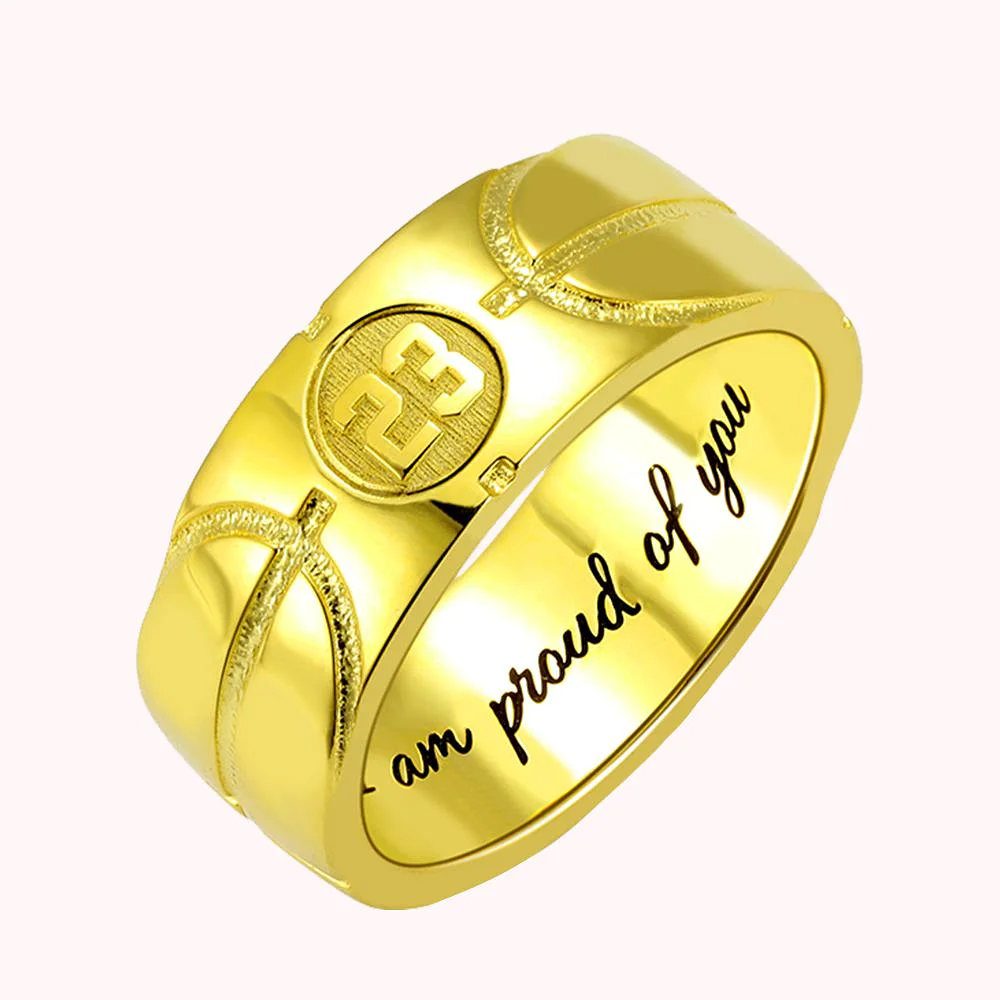 bague en or avec stries d’un ballon de basket, portant le numéro 23 et une phrase intérieure disant “I am proud of you”. 