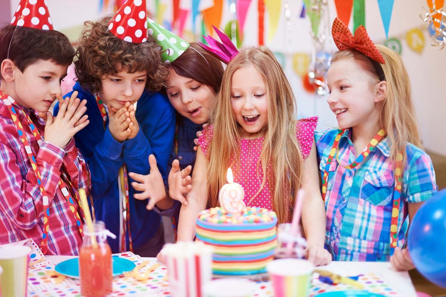 A young girl celebrating her birthday among her friends.
