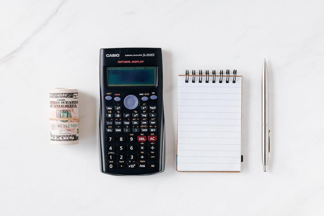 Free Composition of calculator with paper money and notebook with pen Stock Photo
