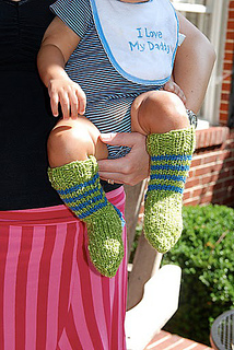 baby wearing a pair of green and blue knit knee high socks